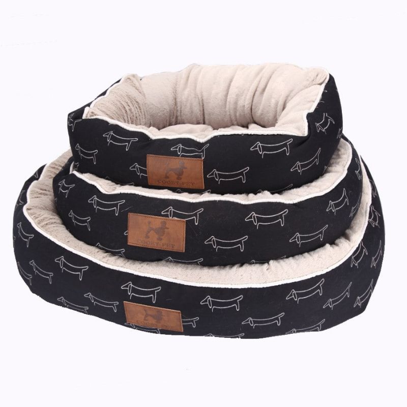 Harvey's Choice Oval Dog Bed: Provide your pet with a cozy retreat! Stylish black exterior with cute dog prints. Available in three sizes. Order now!